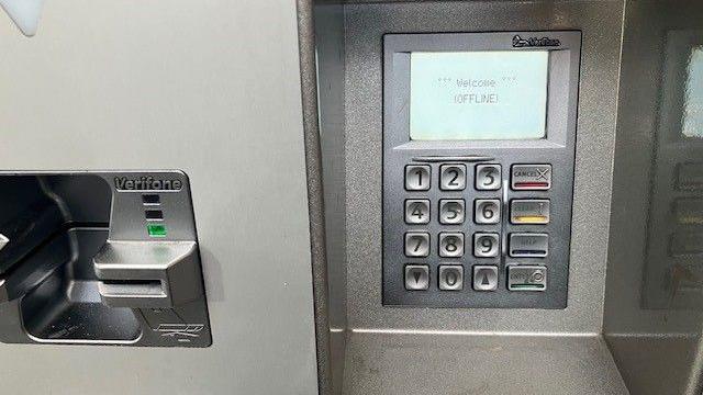A card reader on a ticket machine at Glasgow Queen Street. On the left is a thin card reader slot, which is silver and metallic. A small green light is on next to it. On the right is the card reader display. It has a numbered keyboard and white screen displaying the message "Welcome (OFFLINE)"