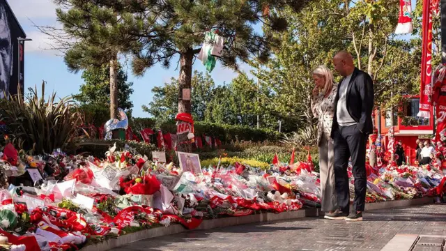  Arne Slot and his wife look at the flowers and tributes placed outside Anfield