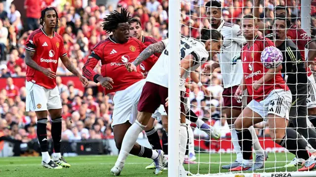 Riccardo Calafiori of Arsenal scores his team's winning goal past Altay Bayindir of Manchester United