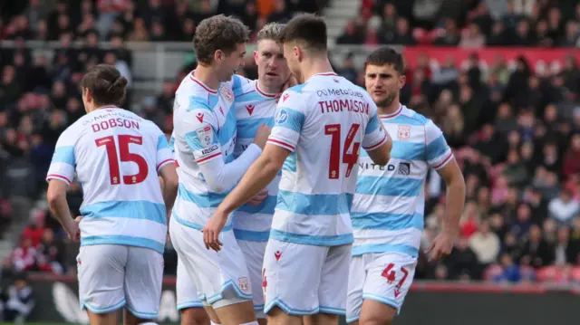Wrexham players Lewis Brunt (L) and George Thomason (R) celebrate with Josh Windass (C)