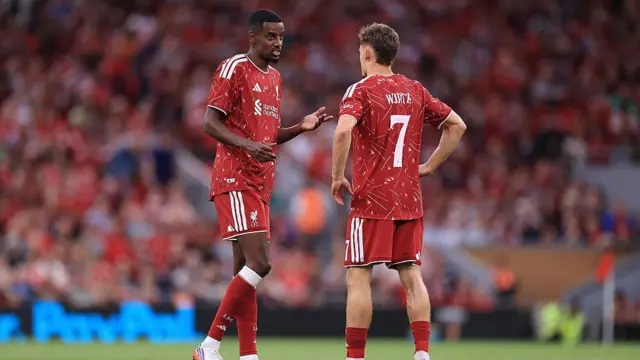 Alexander Isak of Liverpool speaks to Florian Wirtz of Liverpool
