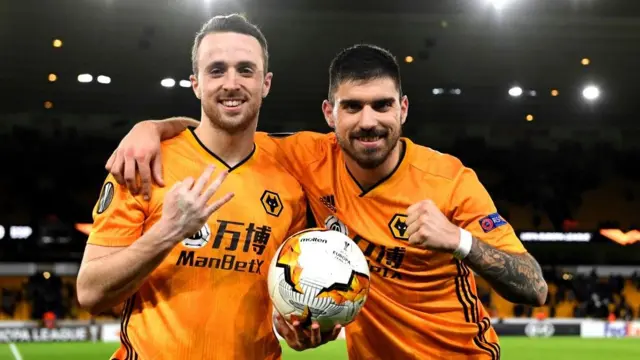 Diogo Jota and Ruben Neves celebrate with the match ball for Wolves after Jota scored a hat-trick