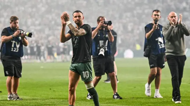 Hibs skipper Martin Boyle applauds the visiting fans in Poland's capital