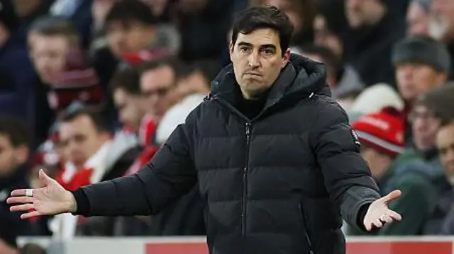 Andoni Iraola holds his arms outstretched