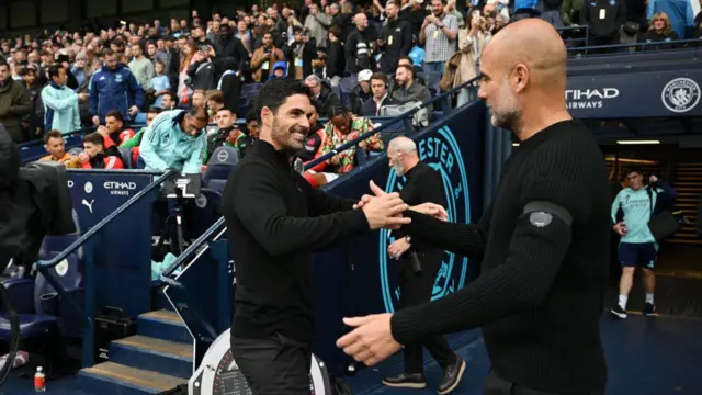 Mikel Arteta, Manager of Arsenal shakes hands with Pep Guardiola, Manager of Manchester City