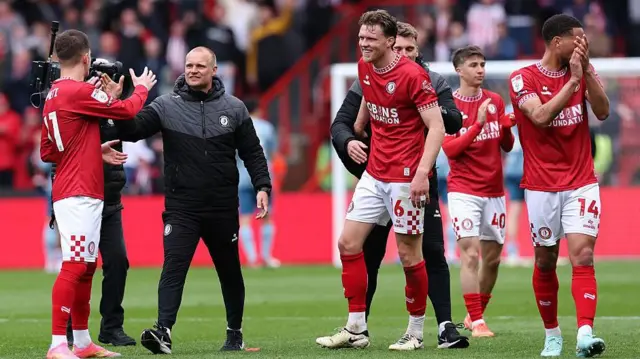 Bristol City players and staff celebrate on the pitch