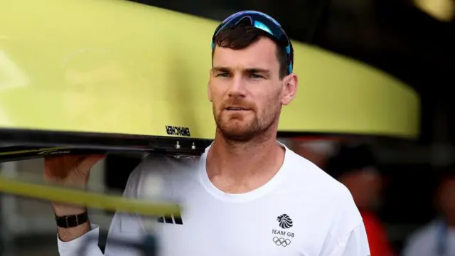 Matt Aldridge carries the boat out at the Rowing at Vaires-Sur-Marne Nautical Stadium