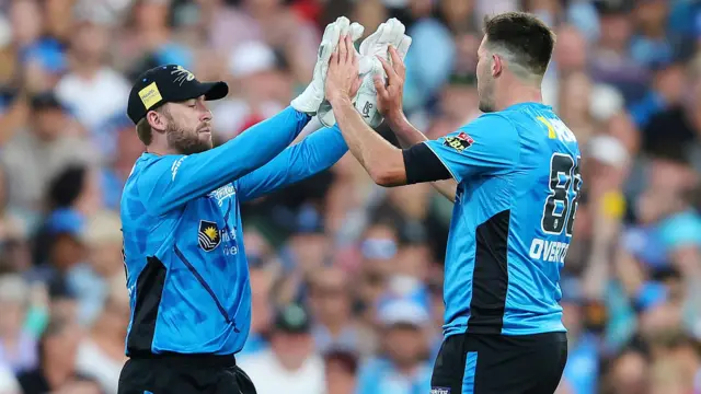 Jamie Overton celebrates a wicket with Adelaide Strikers team-mate MacKenzie Harvey
