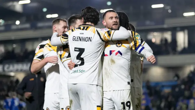 Shane McLoughlin celebrates his penalty at AFC Wimbledon with team-mates 