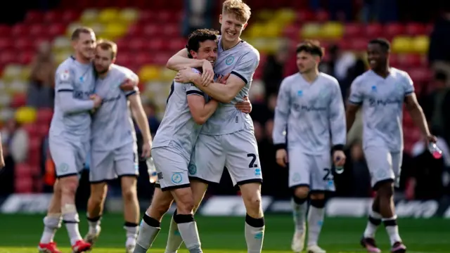 Millwall's George Honeyman [centre-left] and Josh Coburn [centre-right] embrace after the Lions' victory at Watford