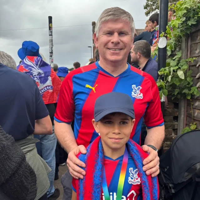 An image of a father and son wearing Crystal Palace home shirts