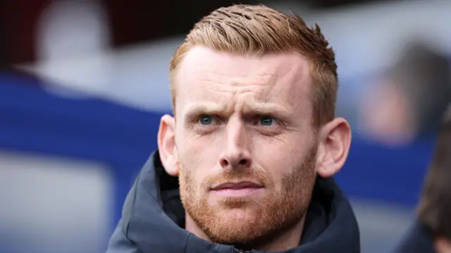 Watford head coach Will Still glancing to his right while standing outside wearing a dark-coloured coat