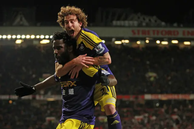 Jose Canas jumps on the back of goalscorer Wilfried Bony