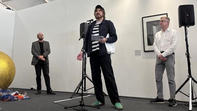 Bedwyr Williams yn ystod seremoni wobrwyo cystadlaethau celf yr Eisteddfod Genedlaethol yn Wrecsam