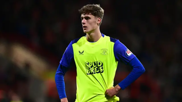 Harrison Armstrong playing for Preston North End in their fluorescent yellow shirt with blue sleeves
