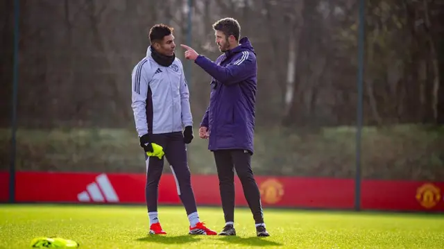 Michael Carrick and Casemiro speak during a first-team training session