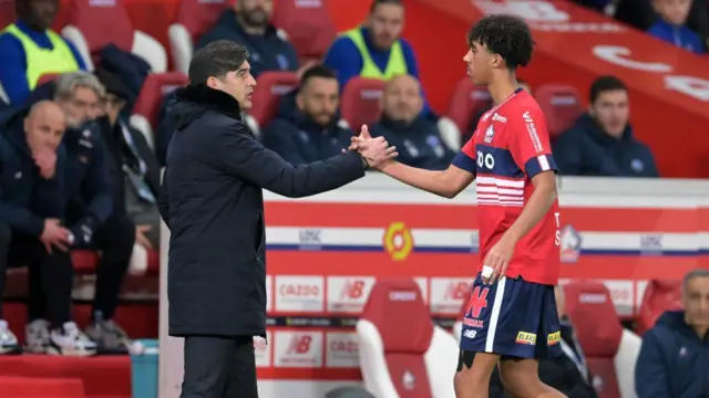 Paulo Fonseca shakes hands with Leny Yoro