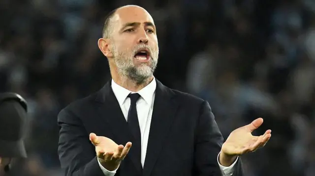 Igor Tudor wears a black suit and black tie on the touchline