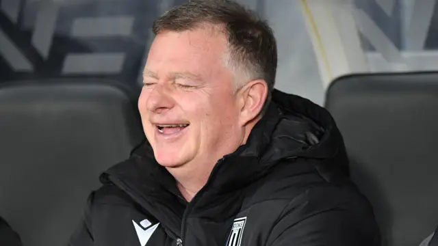 Mark Robins laughing in the Stoke dugout