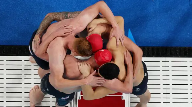 GB's 4x200m freestyle relay team huddle in celebration