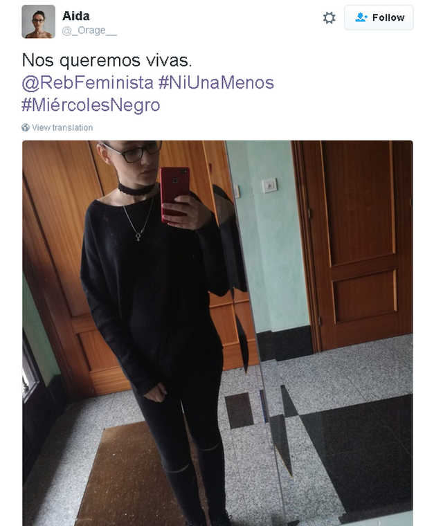 Tweet in Spanish with picture of women wearing black taken in the mirror