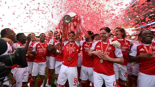 Arsenal captain Martin Odegaard lifts the Premier League trophy.