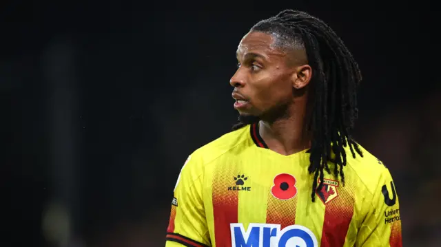 A close-up of Jeremy Petris' side profile as he looks away from the camera in a Watford home shirt