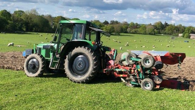 A tractor and plough in a field.