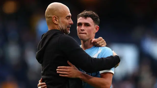 Pep Guardiola embracing Phil Foden
