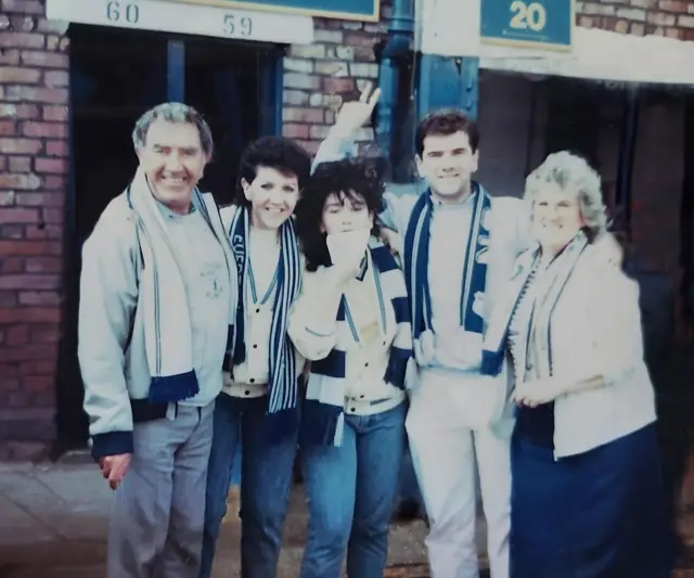 Family of Everton fans in Everton scarves celebrating winning the league in 1987.