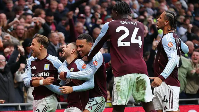Aston Villa players celebrate a goal together