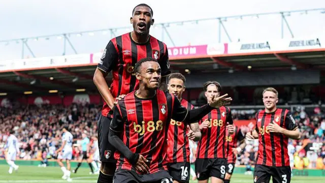 Rayan jumps on Junior Kroupi's back after his goal against Crystal Palace