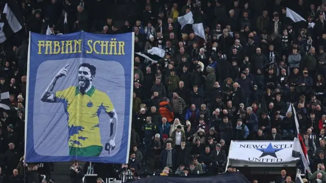 Newcastle fans with a Fabian Schar flag