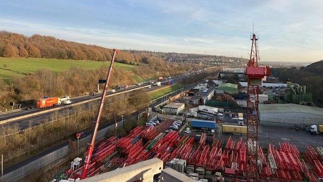 The crane rental site on the side of the M1 during the say.