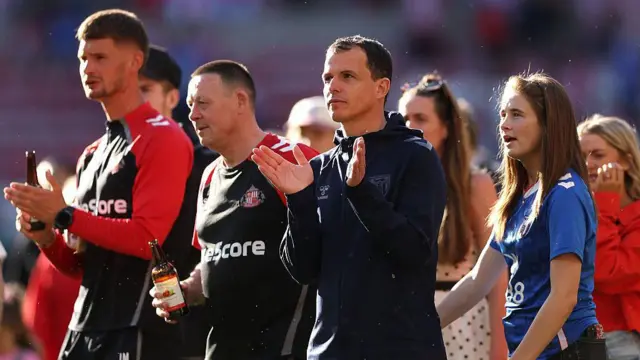 Regis le Bris applauding towards fans after Sunderland qualify for the Europa League