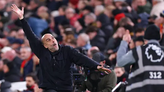 Pep Guardiola mimicks a save made by Gianluigi Donnarumma while on the touchline at Anfield