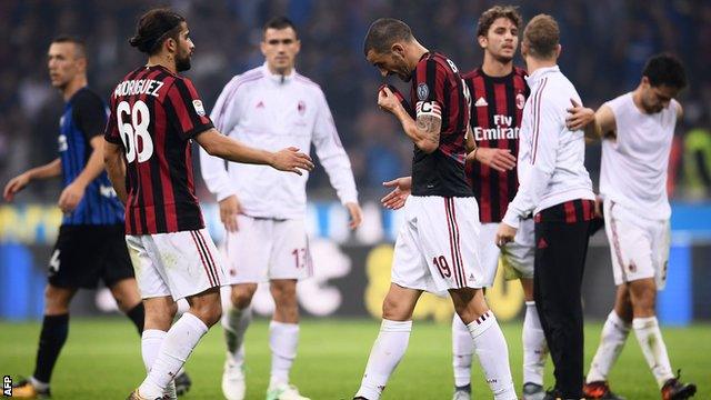 AC Milan players react at the end of their 3-2 defeat to Inter Milan