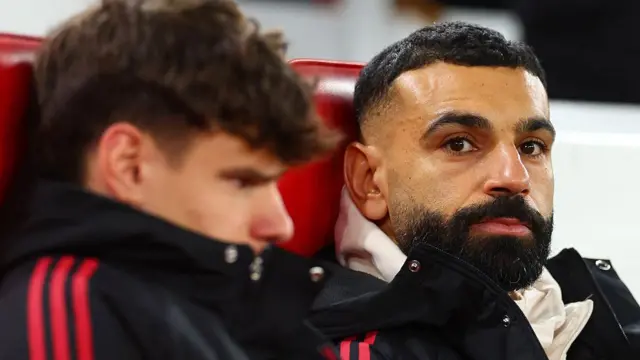 Mohamed Salah (R) looks on from the substitute's bench