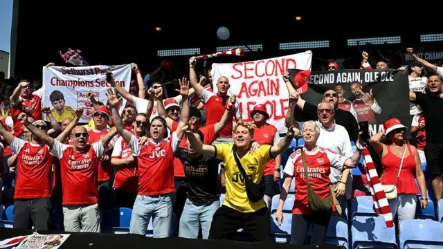 Arsenal fans celebrate in the Selhurst Park away end