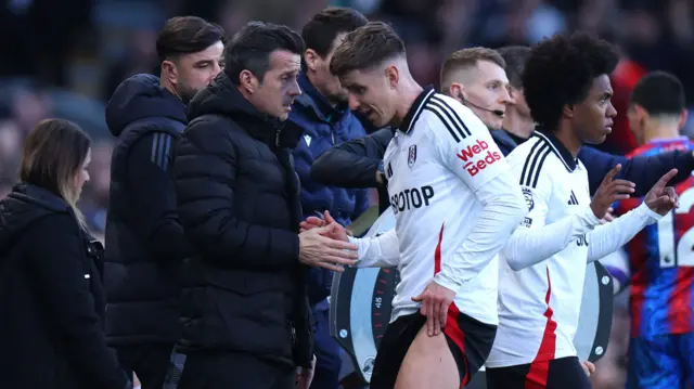 Marco Silva, manager of Fulham, shakes hands with Tom Cairney as he leaves the pitch with a injury.