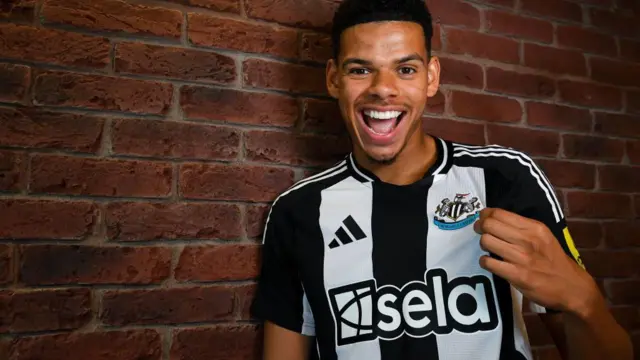 William Osula poses in a Newcastle United shirt