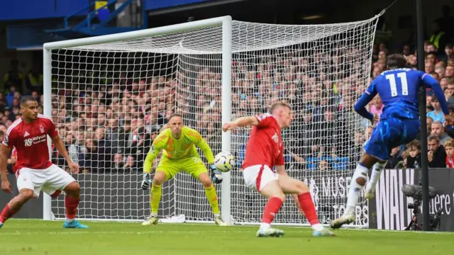 Noni Madueke of Chelsea shoots at goal as Matz Sels, Nottingham Forest goalkeeper, makes a save