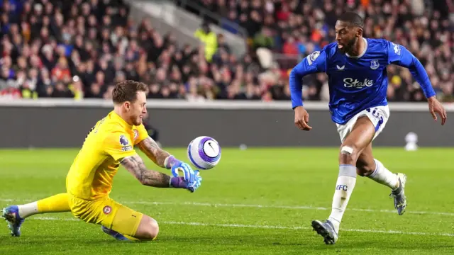 Brentford goalkeeper Mark Flekken saves a shot from Everton's Beto.