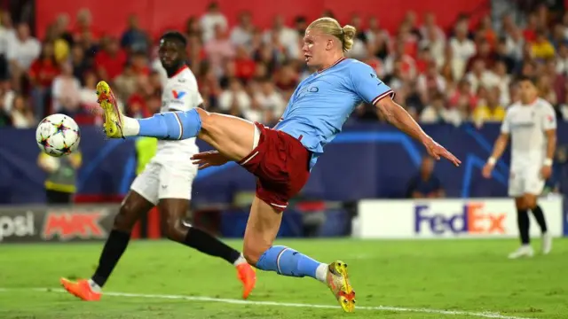 Haaland stretches and pokes the ball into the net against Sevilla in Champions League group G match between Sevilla FC and Manchester City at Estadio Ramon Sanchez Pizjuan on September 06, 2022