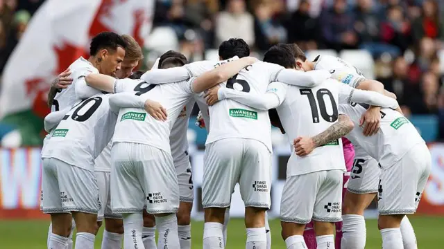 Swansea players in a huddle before a game 