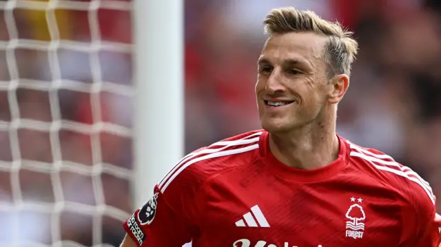 Chris Wood, wearing Nottingham Forest's red home strip, smiles after scoring against Wolves.