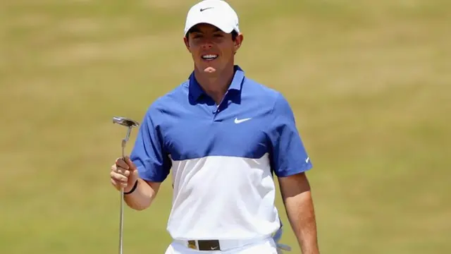 Rory McIlroy holds up his putter