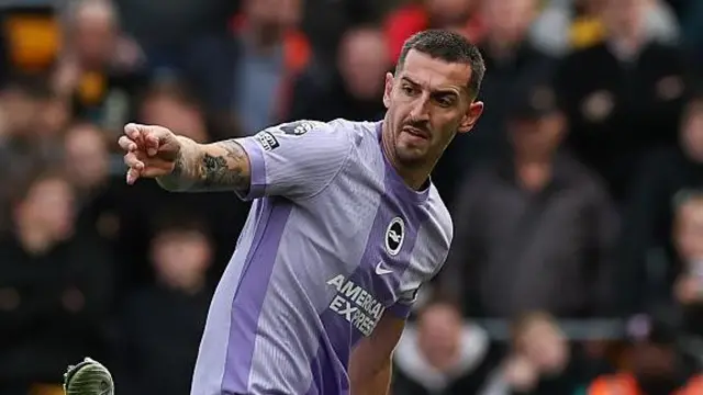 Lewis Dunk contests a challenge. He wears Brighton's away colours.