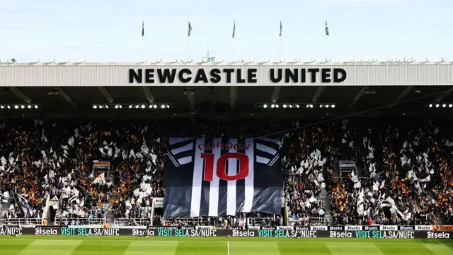 General view inside the stadium as fans hold a flag featuring the shirt of Anthony Gordon of Newcastle United prior to the Premier League match between Newcastle United FC and Manchester City FC at St James' Park