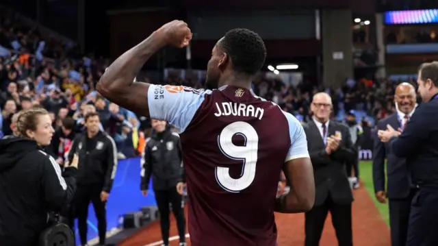 Jhon Duran points to name and number on back of shirt